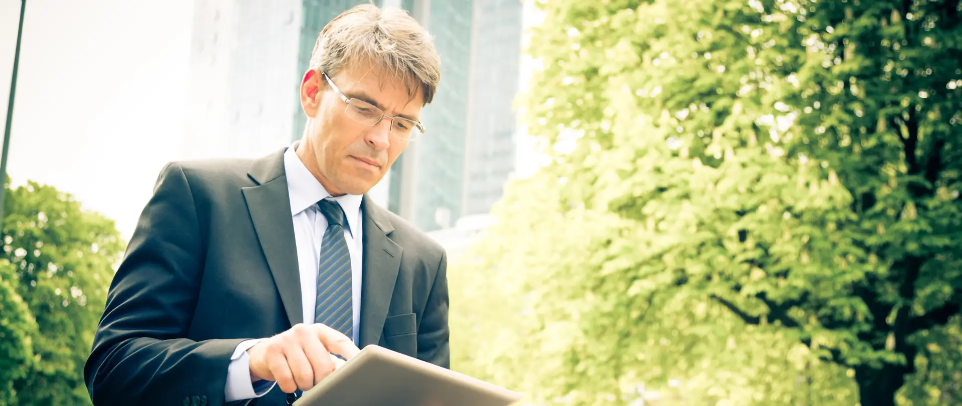 Business man concentrato a lavorare con un tablet in un parco pubblico.