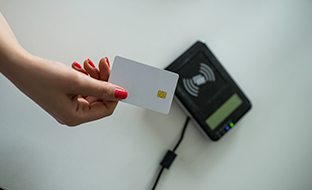 A female hand holds a smart card close to a reader