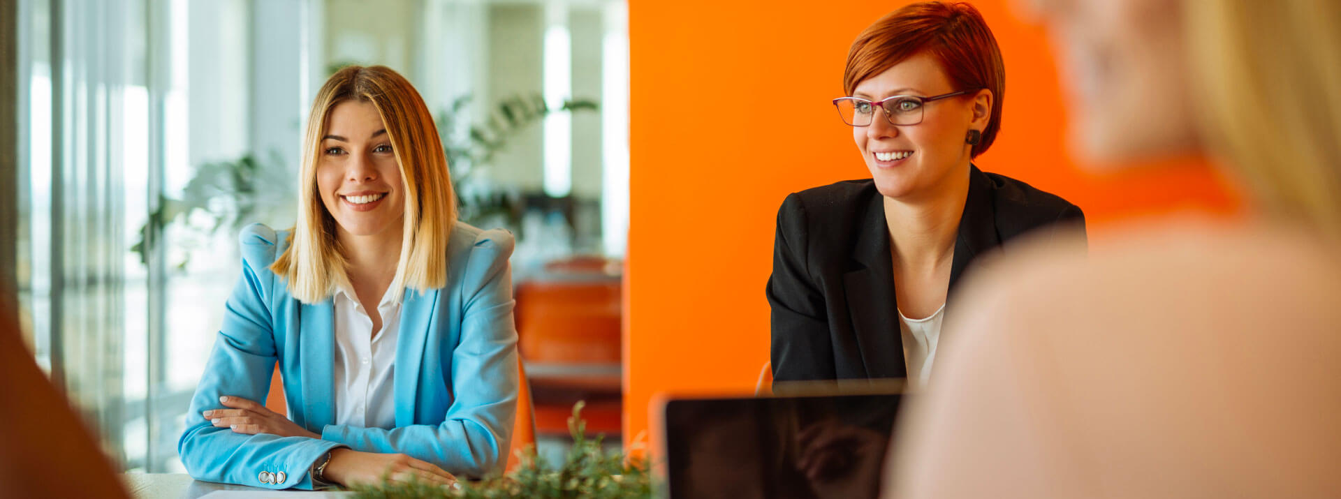 Tre donne sedute a un tavolo durante un colloquio di lavoro.