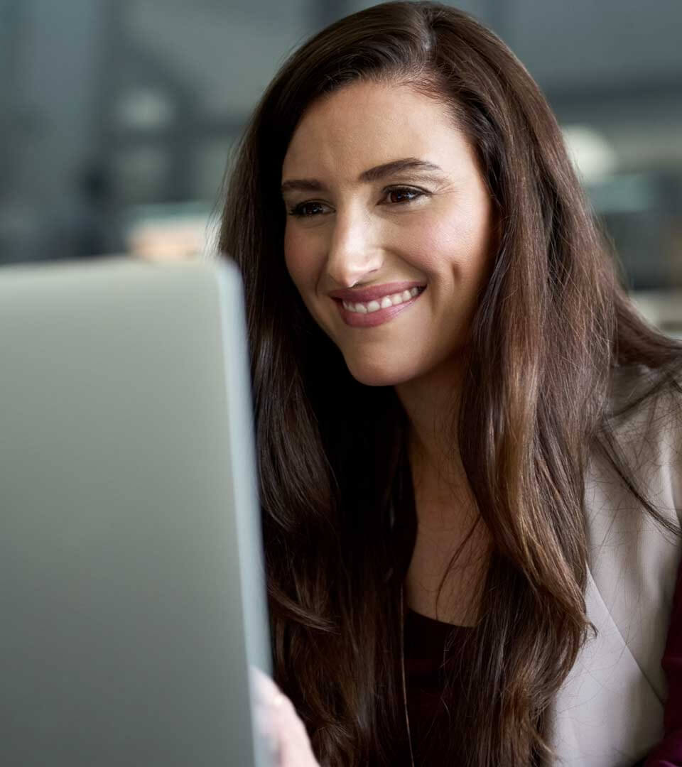 Smiling woman in front of a laptop